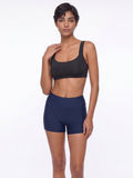 Sienna Swim Bra in black styled with navy swim shorts on a model showcasing supportive swimwear with a comfortable fit for every body