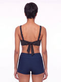 Sienna Swim Bra shown from the back with adjustable straps and a tie detail paired with navy swim shorts for supportive modest swimwear designed for every body