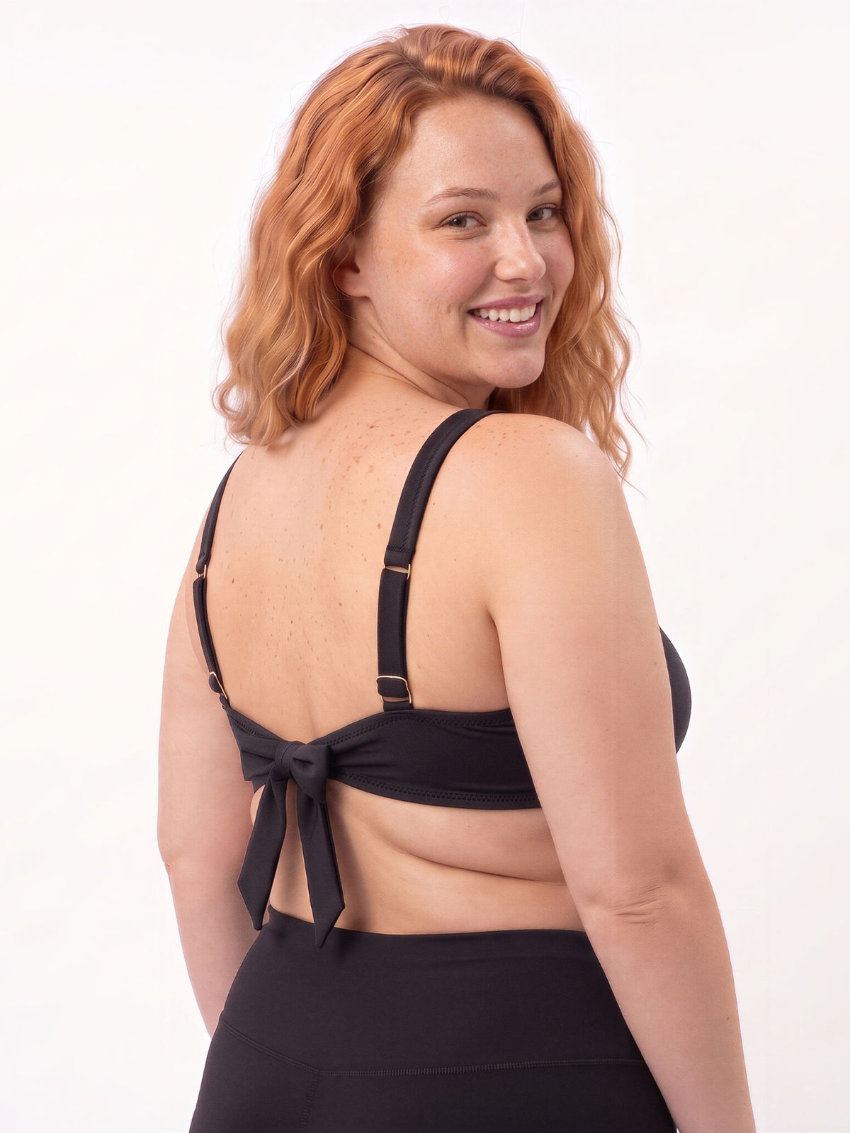 Sienna Swim Bra | Plus Size shown from the back on a smiling model with adjustable straps and tie closure for supportive swimwear designed for every body