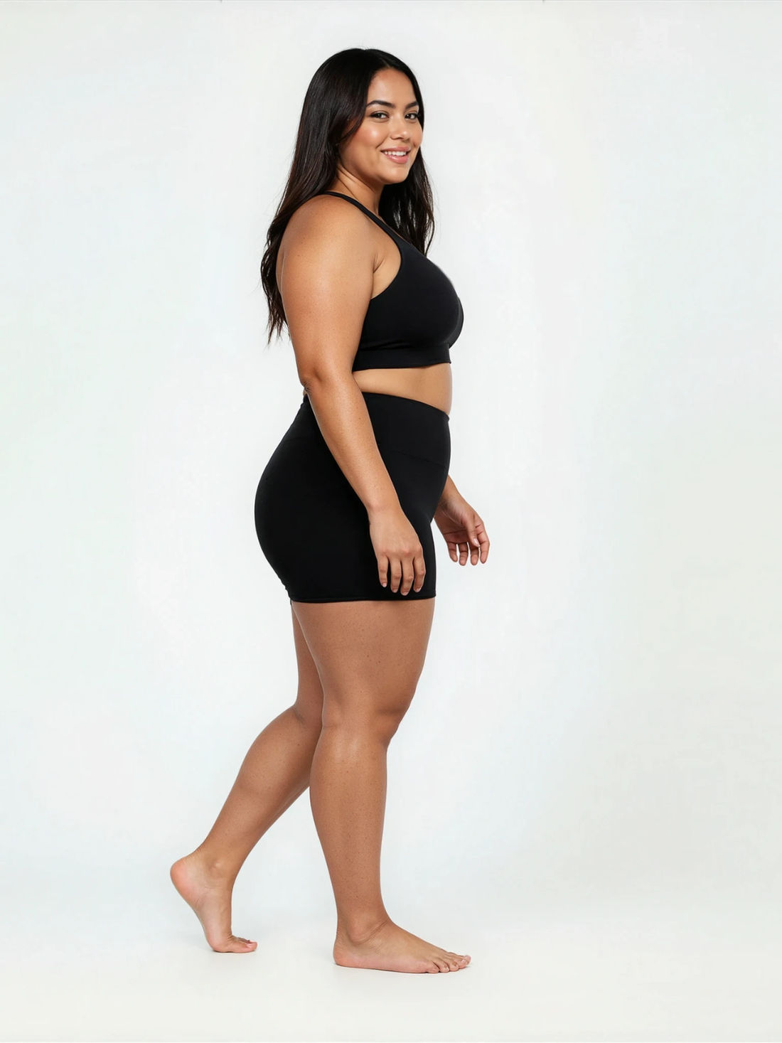 Swim Shorts | Plus Size shown on a woman walking through shallow ocean water in navy swim shorts and a black top. Size-inclusive modest swimwear for every body