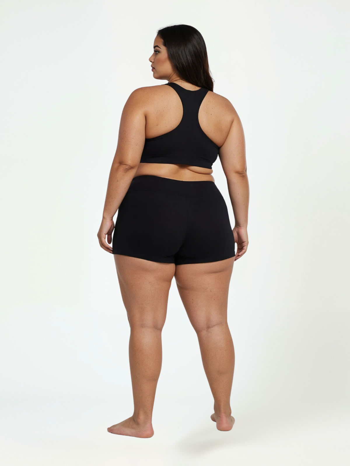 Swim Shorts | Plus Size shown from the back on a curvy woman wearing black swimwear with a comfortable fit. Swimwear designed for every body.