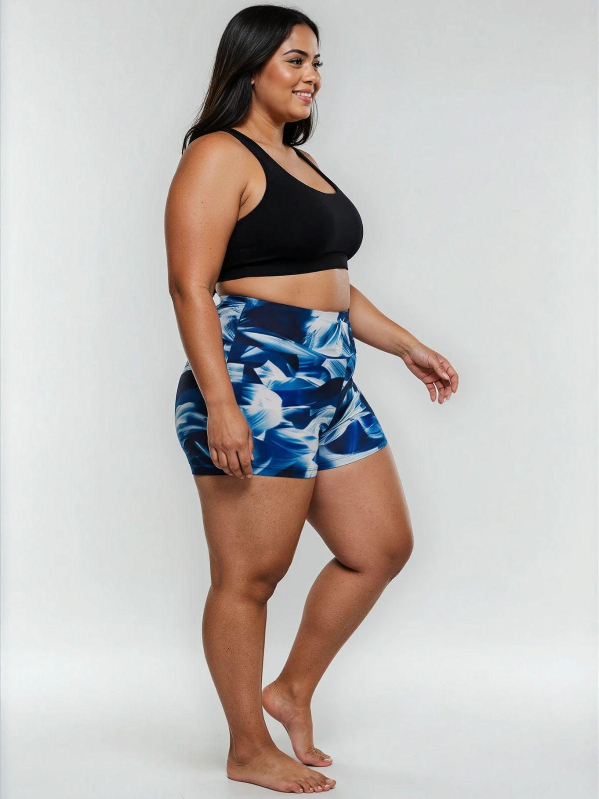 Swim Shorts | Plus Size shown on a smiling woman in blue patterned high waisted swim shorts and a black swim top for a comfortable flattering fit.