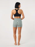 Swim Shorts with green and white vertical stripes shown from the back on a woman wearing a black swim top with a comfortable fit