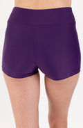Purple athletic shorts worn by a person on a white background