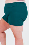 Teal shorts worn by a person on a white background