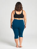 Woman wearing Capri Swim Leggings | Plus Size in space blue, shown from behind, highlighting size-inclusive, comfortable, supportive swimwear designed for every body with a modest fit.