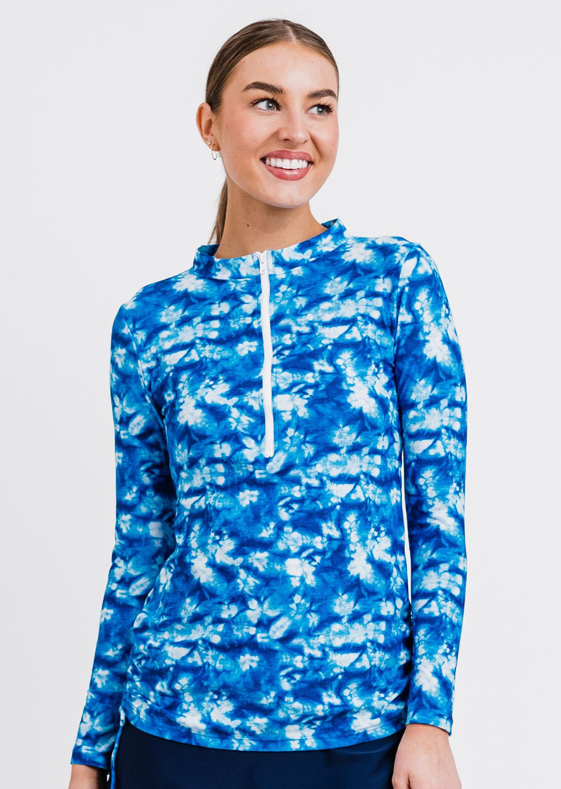 Smiling woman wearing a rust-colored Half-Zip Nora Swim Top | Final Sale with long sleeves and a front zipper, styled with floral swim bottoms, showcasing size-inclusive, modest, supportive swimwear designed for every body with a comfortable fit.