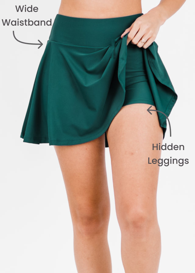 Green skirt with wide waistband and hidden leggings feature on a white background