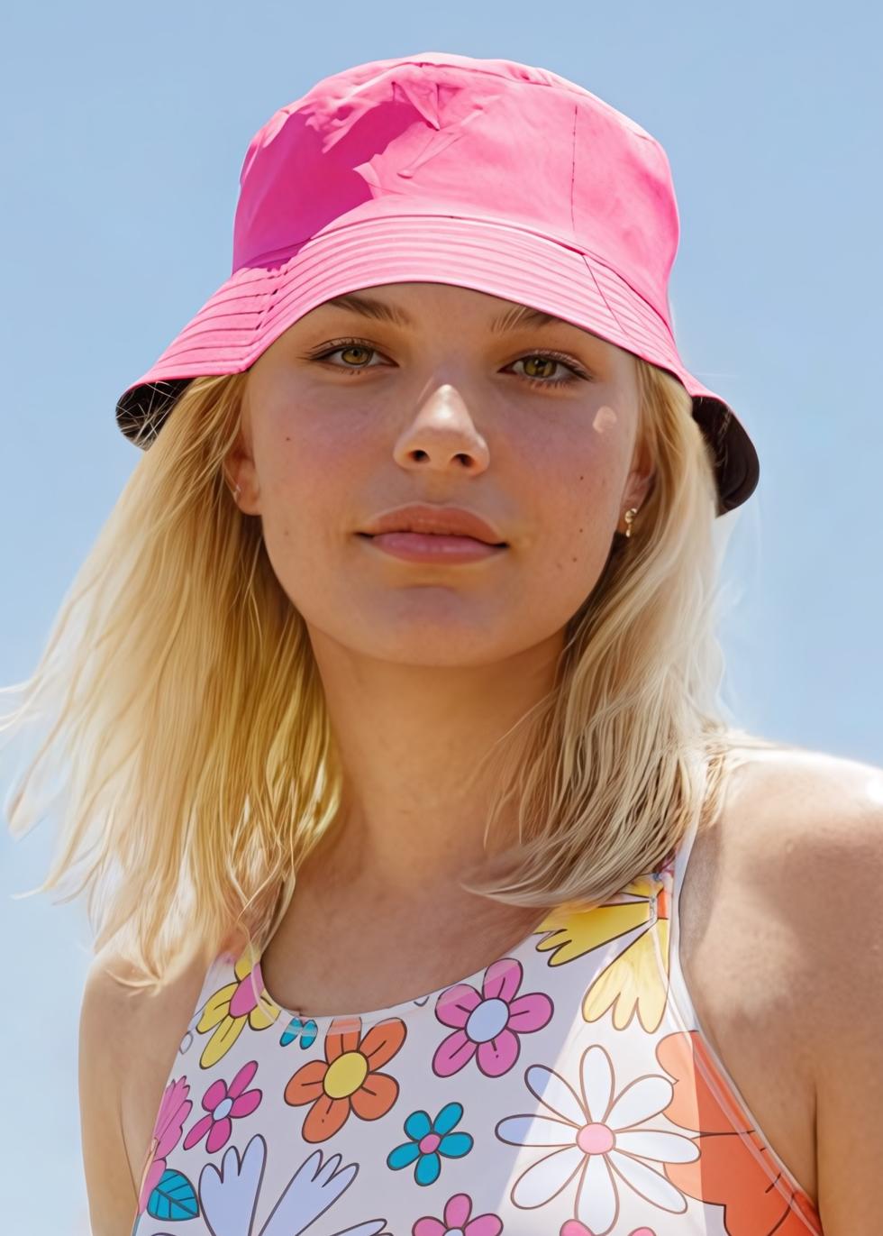 Woman wearing a floral bucket hat and matching blue floral swimwear, showcasing a comfortable fit with supportive and size-inclusive style. Swimwear designed for every body.