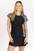 Woman wearing a black dress with colorful floral sleeves on a white background