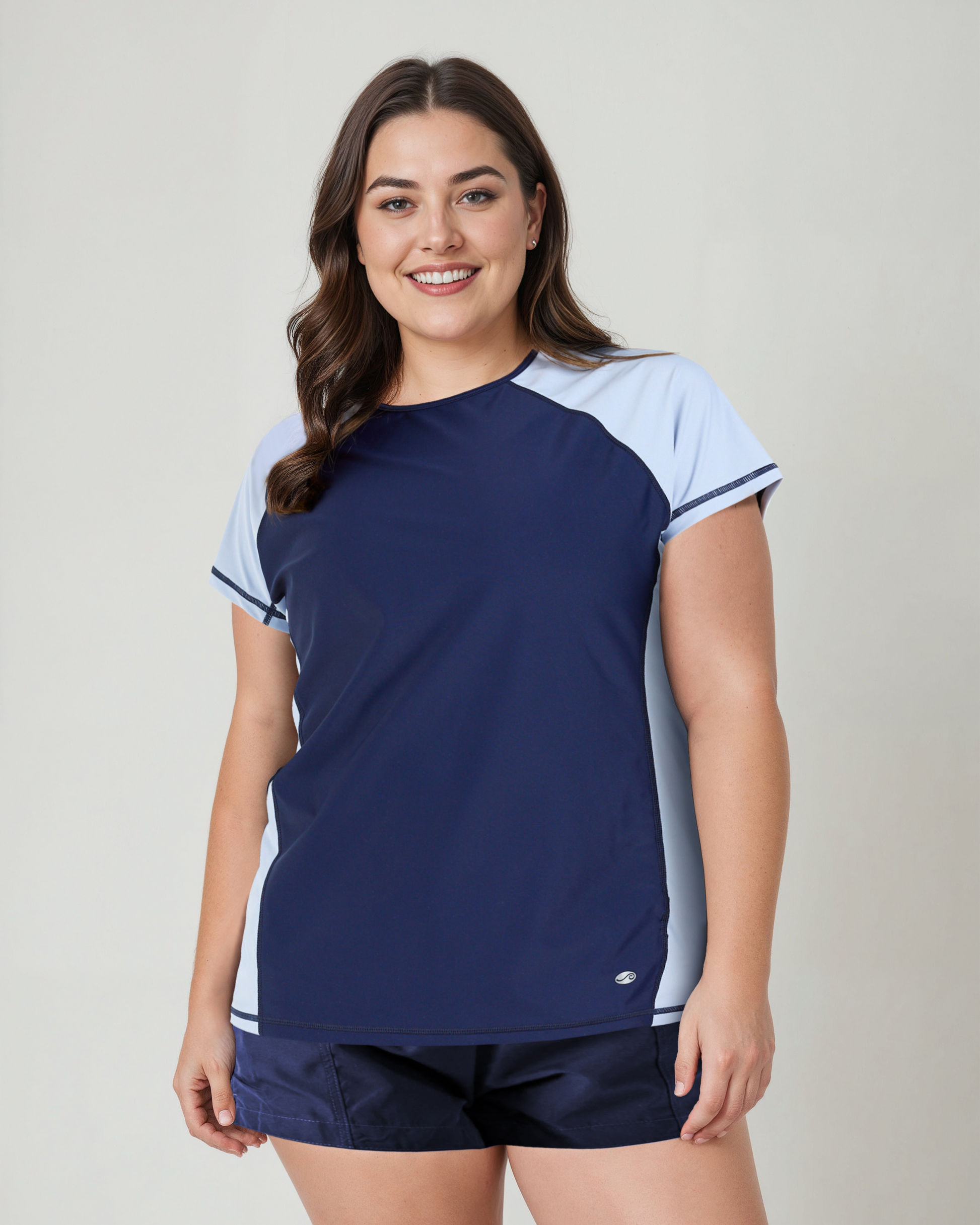 Woman wearing a navy and light blue athletic outfit on a plain background