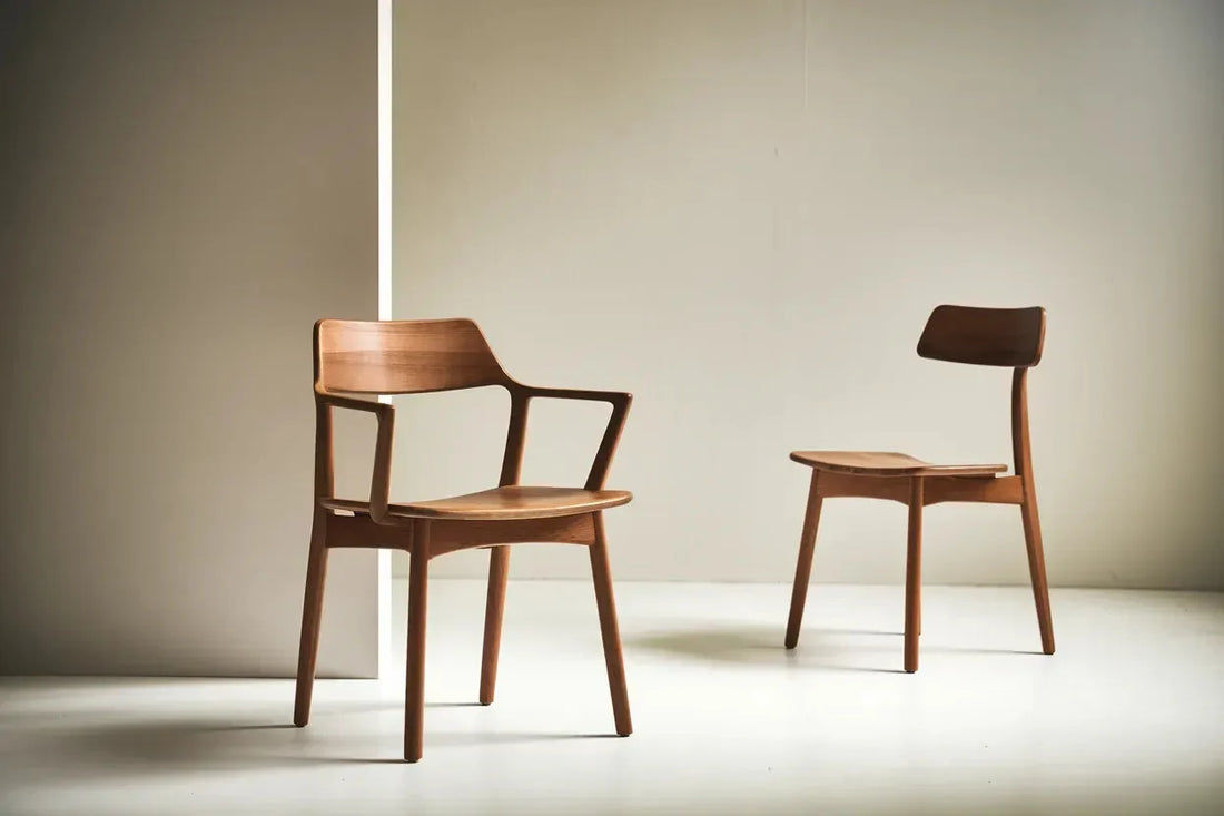 Two wooden chairs with minimalist design against a neutral backdrop.