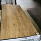 A large rectangular wood-look panel or tabletop with a light to medium brown grain pattern, resting on a white support frame in an indoor setting.