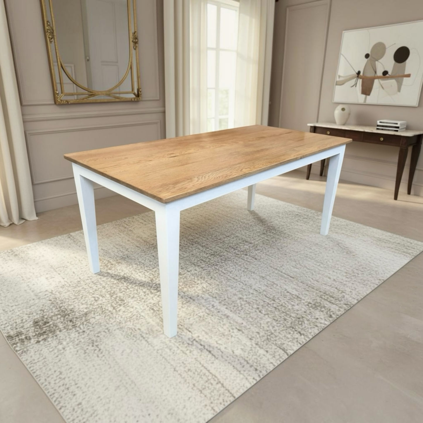A rectangular dining table with a light oak wood top and white legs, placed on a textured cream rug in a bright, modern dining room.