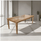 A rectangular wooden dining table with a natural oak finish and four tapered legs, shown in a modern minimalist room with gray walls and large windows.