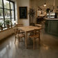 A rustic wooden dining table with four matching wooden chairs in a cozy, modern cafe setting with a concrete floor, potted plants, and a chalkboard menu.