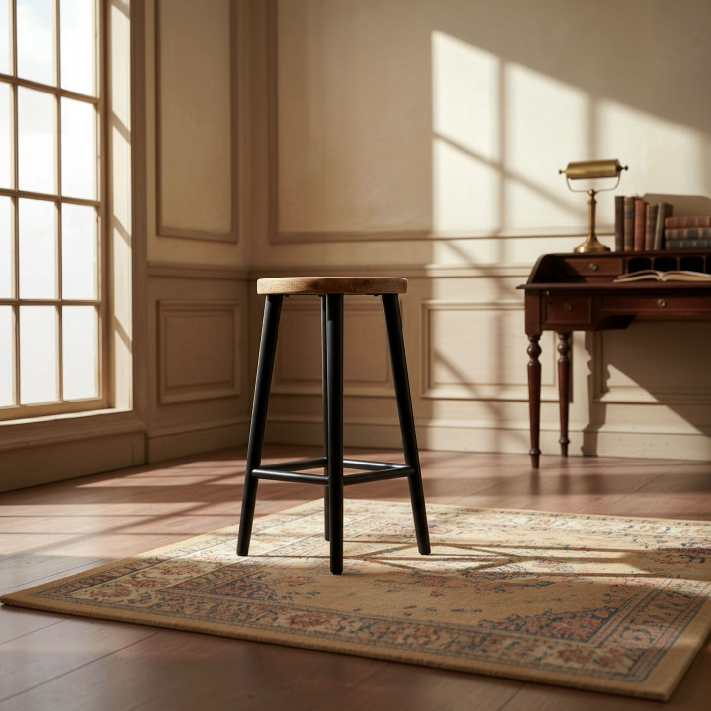 A wooden bar stool with black legs stands on a patterned area rug in a sunlit room with a desk and window in the background.