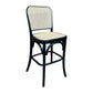 A bar stool with a black bentwood frame and woven cane backrest and seat, shown on a plain white background.