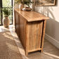 A rustic wooden sideboard or buffet table with a natural wood finish, styled in a bright, modern room with plants and decorative bowls on top.