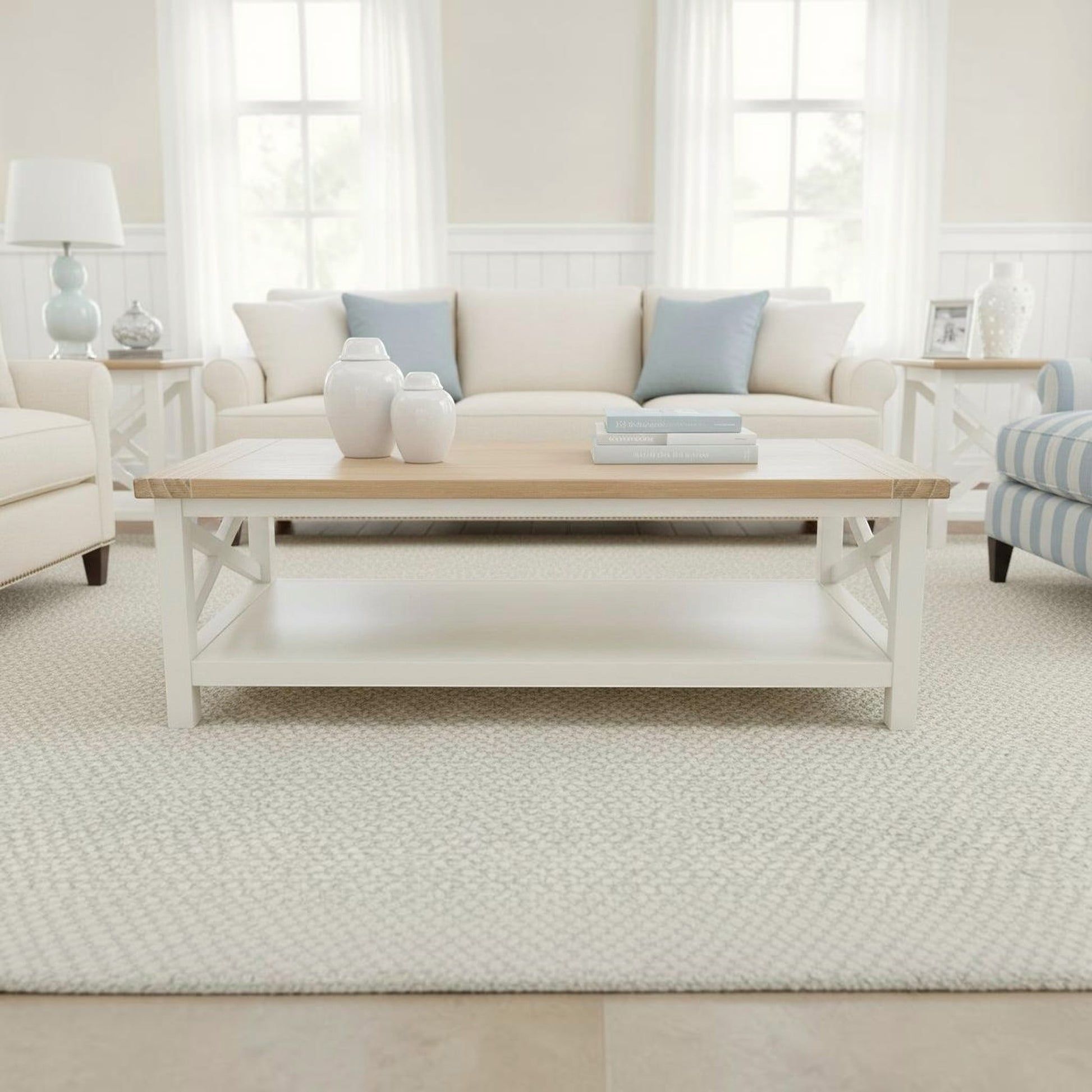 A white and light wood coffee table in a bright, modern living room setting with a cream sofa, decorative vases, and a textured rug.