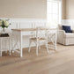 A white writing desk with a light wood top and a matching white chair with a woven seat, styled in a bright, modern room with beige walls and light wood floors.