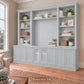 Harrington 5-piece wall unit in Dulux Grey Pail, styled with books, vases and plants, angled view with frosted glass centre doors