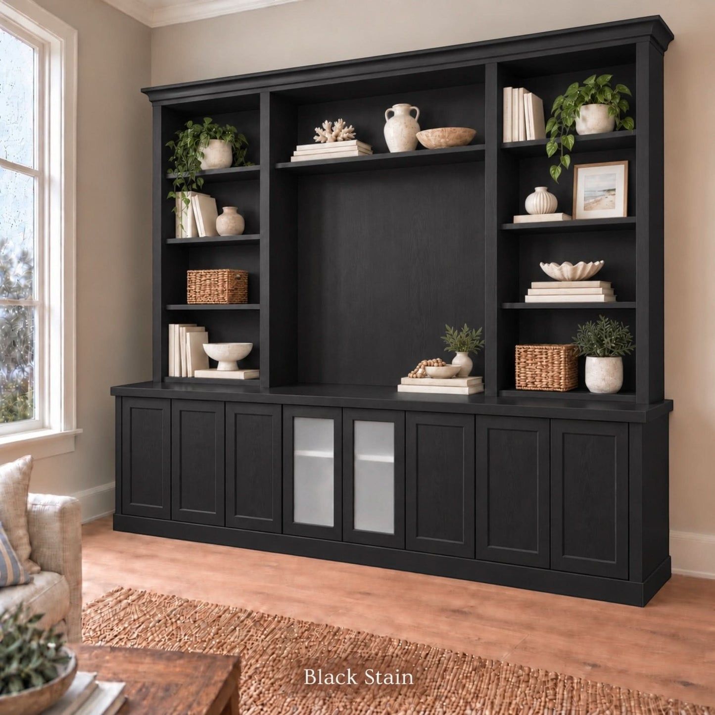 Harrington 5-piece wall unit in Black Stain, styled with books, vases and plants, angled view with frosted glass centre doors