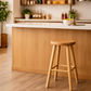 Natural oak stool by MyChocolateWood with a solid wood top and natural legs, height 65cm, shown in a setting with two stools.