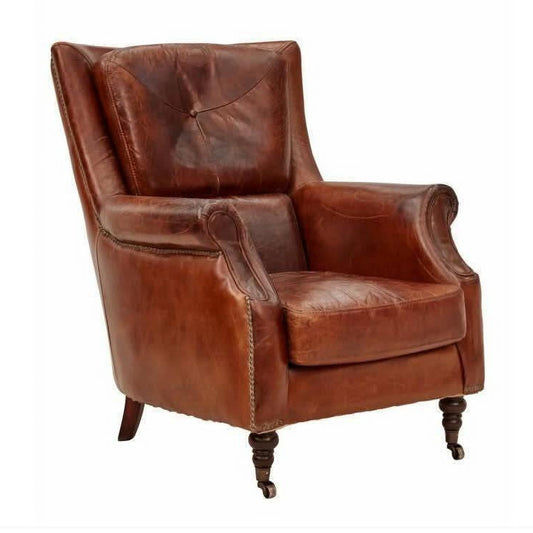 Aged leather Cleopatra arm chair by Chocolate Wood with plush cushioning and elegant design, shown in a cozy living room setting.