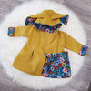 Yellow coat with floral patterns on a white fur rug