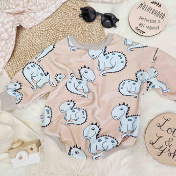 beige sweater romper for babies and toddlers featuring a cute blue dinosaur motif