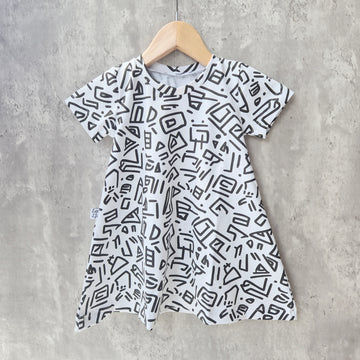 monochrome dress with bold 90s-inspired abstract print in black and white. Soft cotton jersey, A-line shape and short sleeves for toddlers and babies.