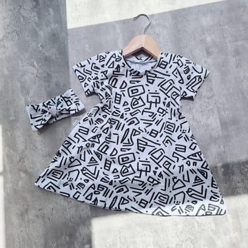 T-shirt dress with bold 90s-inspired abstract print in black and white. Soft cotton jersey, A-line shape and short sleeves for toddlers and babies.