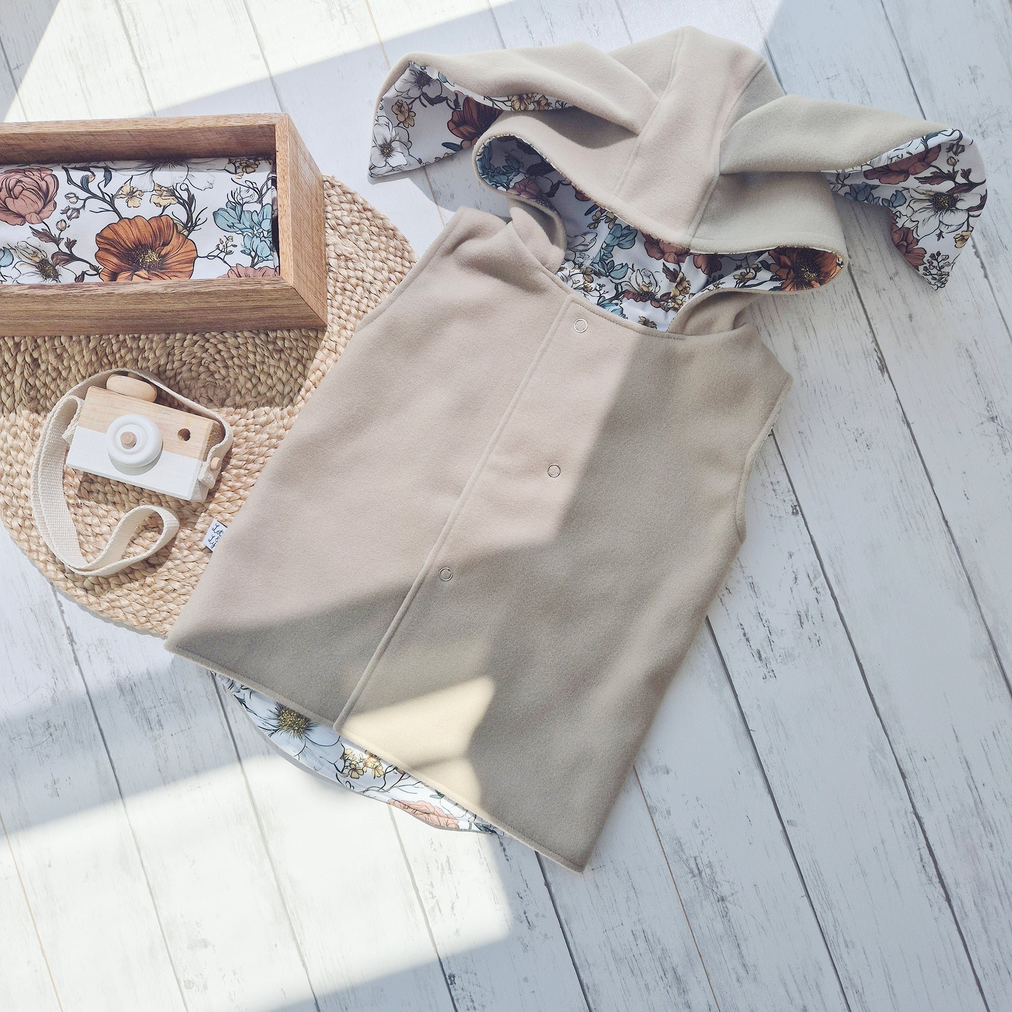 Reversible beige bunny gilet with ears, made from vegan wool and lined in floral jersey. Handmade baby and toddler bodywarmer.