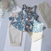 A girls printed peplum vest with bunny and flower detail. Pictured alongside a pair of neutral cotton baggy trousers with pinstripe detail. Entire outfit ethically handmade in the UK, by award winning kid's brand Lottie & Lysh.