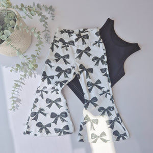 flared bow print trousers by Lottie & Lysh. Flat lay image with a black vest top.