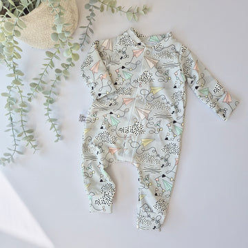 Children's onesie with paper plane pattern on a light background