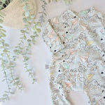 Baby romper with geometric plane and kite pattern on a light background