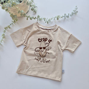 Beige t-shirt with a graphic design on a light background - crop it like its hot