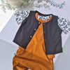 Children's outfit with black and orange design on a light gray background