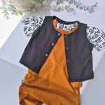 Children's outfit with black and orange design on a light gray background