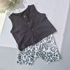 Black sleeveless top and white shorts with black geometric pattern on a light gray background