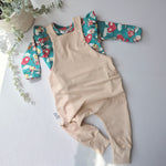 light beige overalls with cherub print frill shoulder long sleeve top underneath