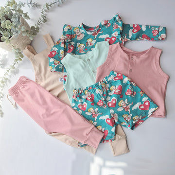 Children's clothing set with floral and cherub pattern on a light background