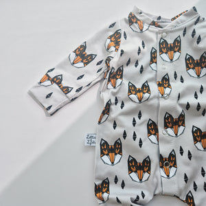 Baby onesie with fox pattern on a light gray background