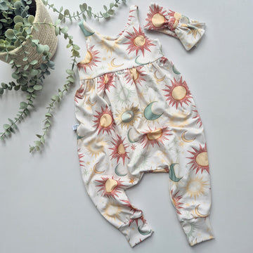 Baby romper with celestial pattern and matching headband on a light gray background