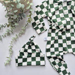 Green and white checkered baby outfit with matching hat on a light background