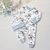 Baby outfit set with white onesie and hat with text and footprints on a light gray background.