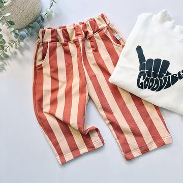 Striped pants and a white sweatshirt with text on a light background