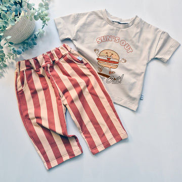 Children's t-shirt with graphic design and striped pants on a light background